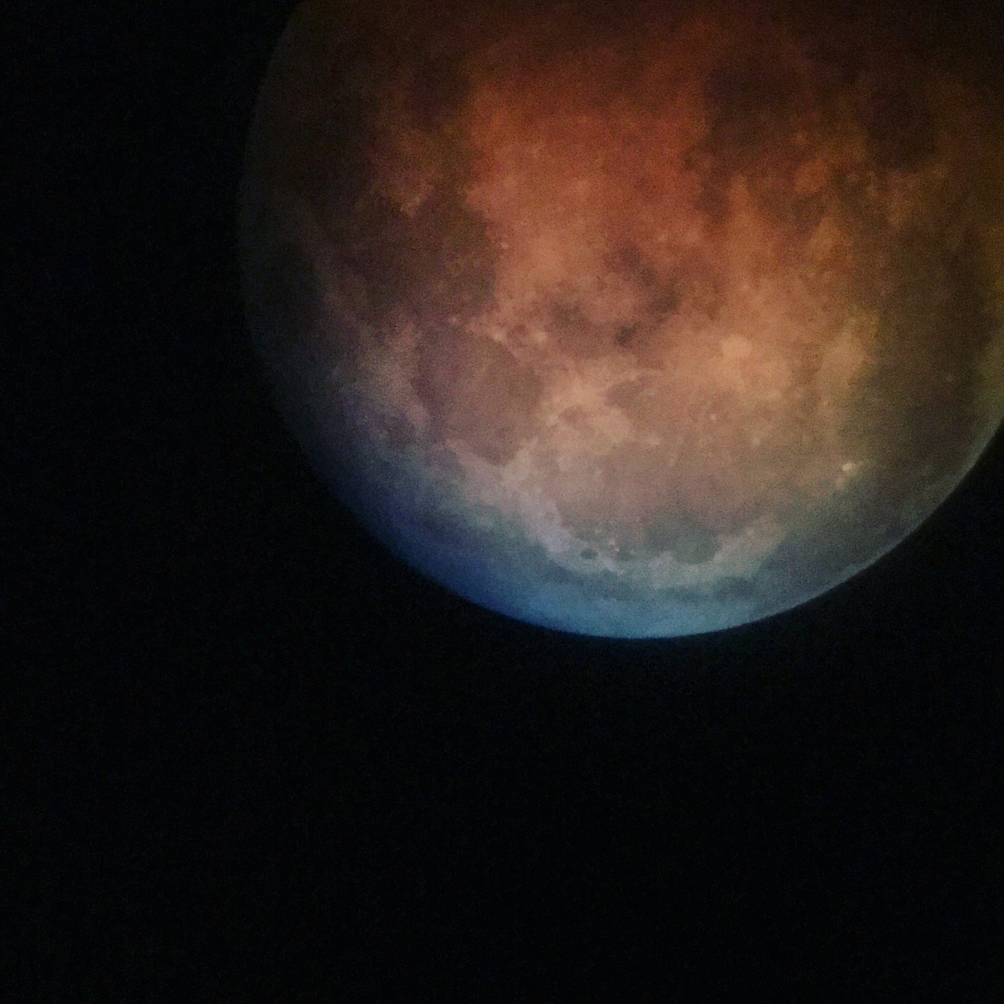 The final minutes of totality of the lunar eclipse, a hint of blue grey comes into view as the ruddy color cast by Earth's shadow fades.