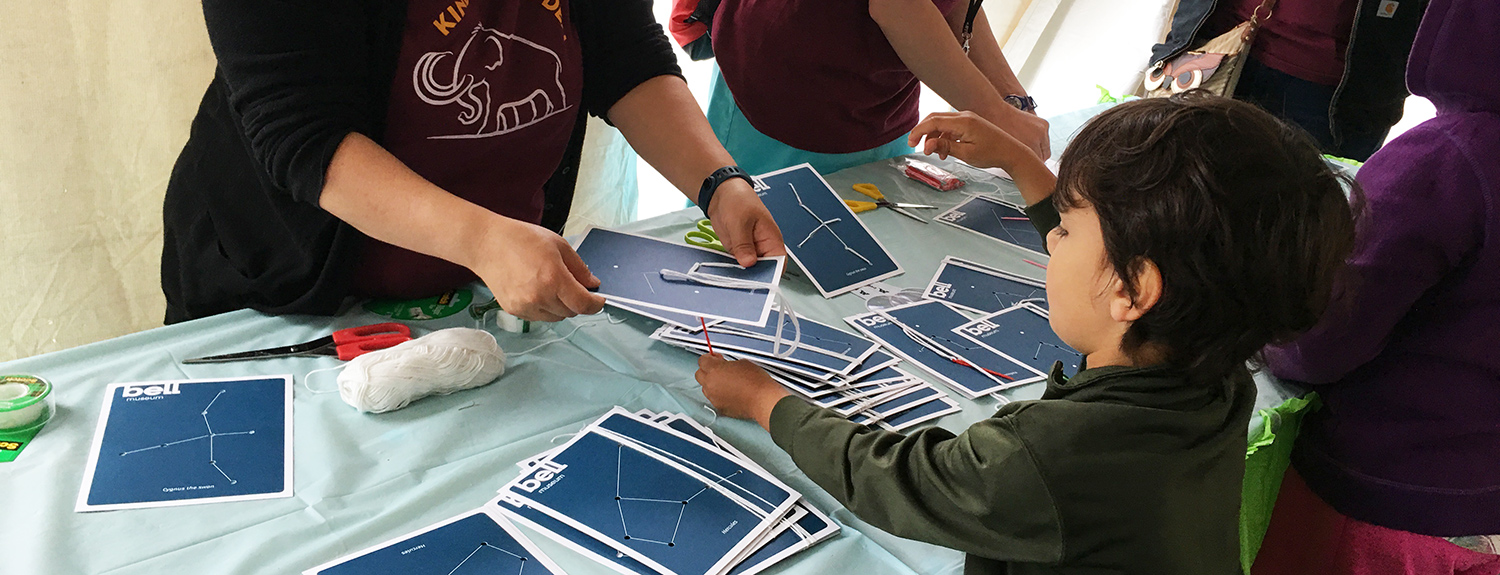 A child works on a constellation card activity at a Bell event