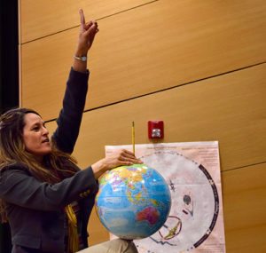 Woman with a globe, pointing up
