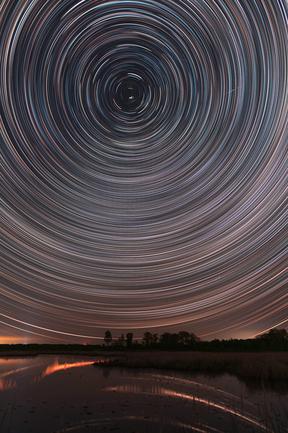 Many circular star trails over nighttime landscape