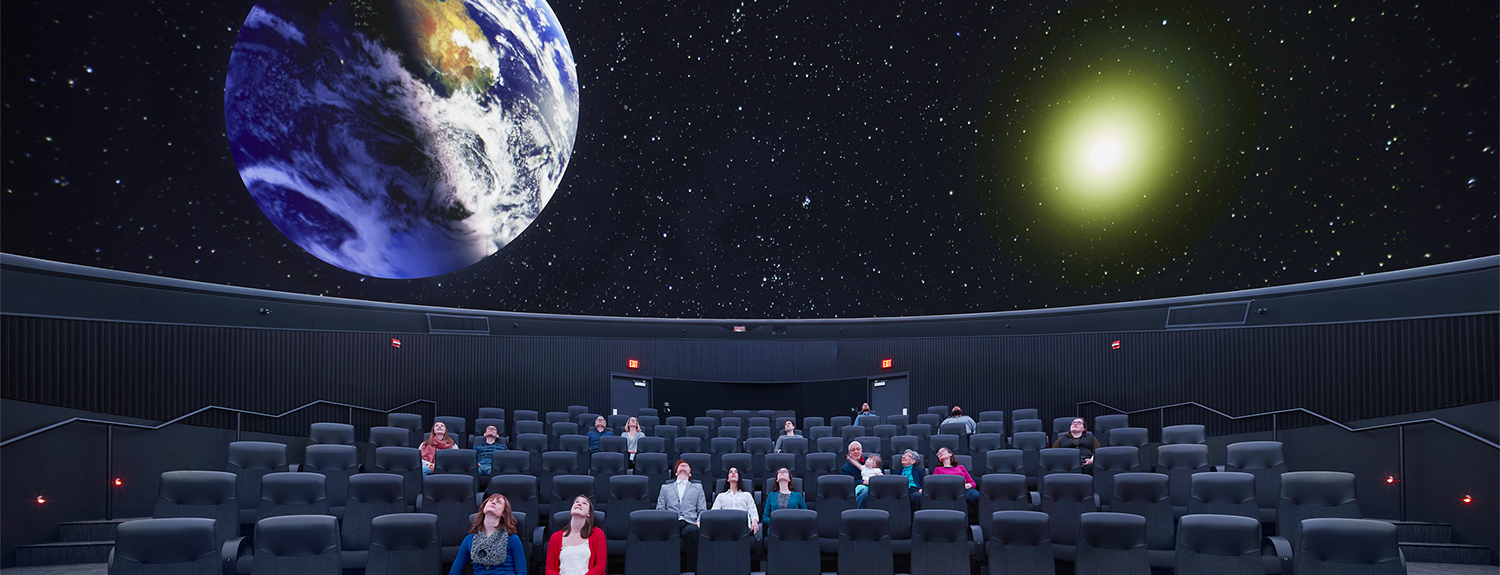 Small crowd looking up in the planetarium