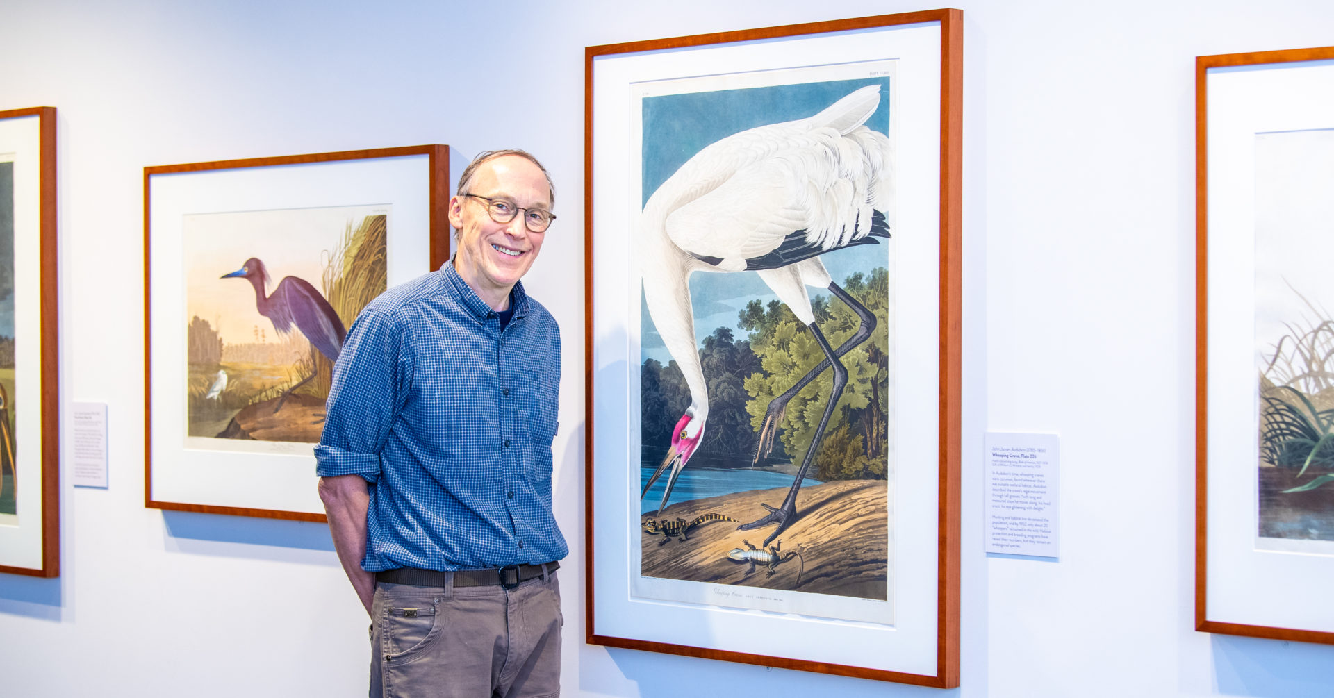 Don Luce standing next to an illustration of a bird