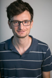 A man with brown hair and glasses