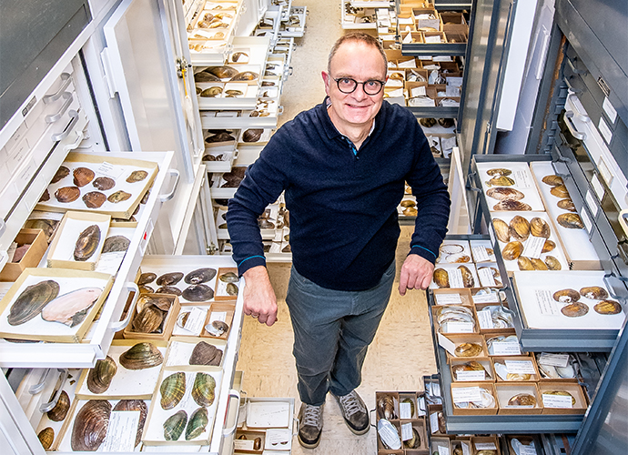 Andrew Simons standing in collections with drawers of specimen opened