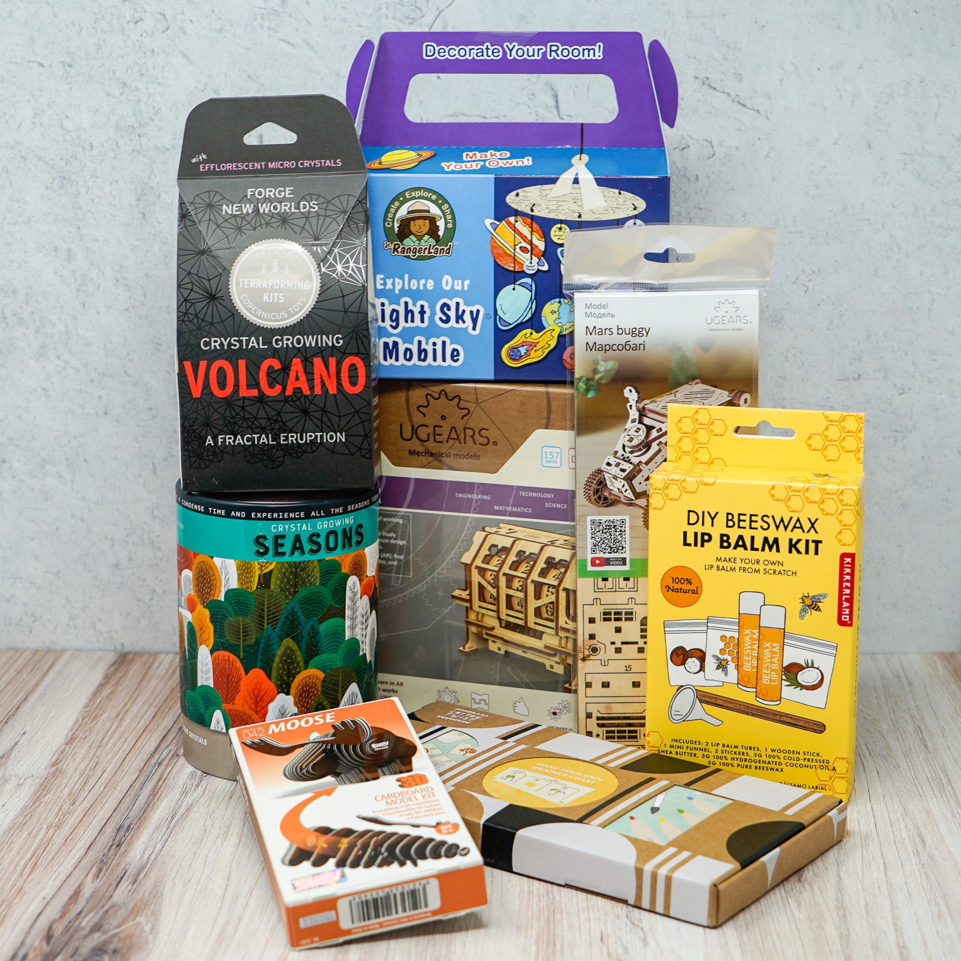 An assortment of gifts such as a build your own volcano kit and make your own lip balm kit