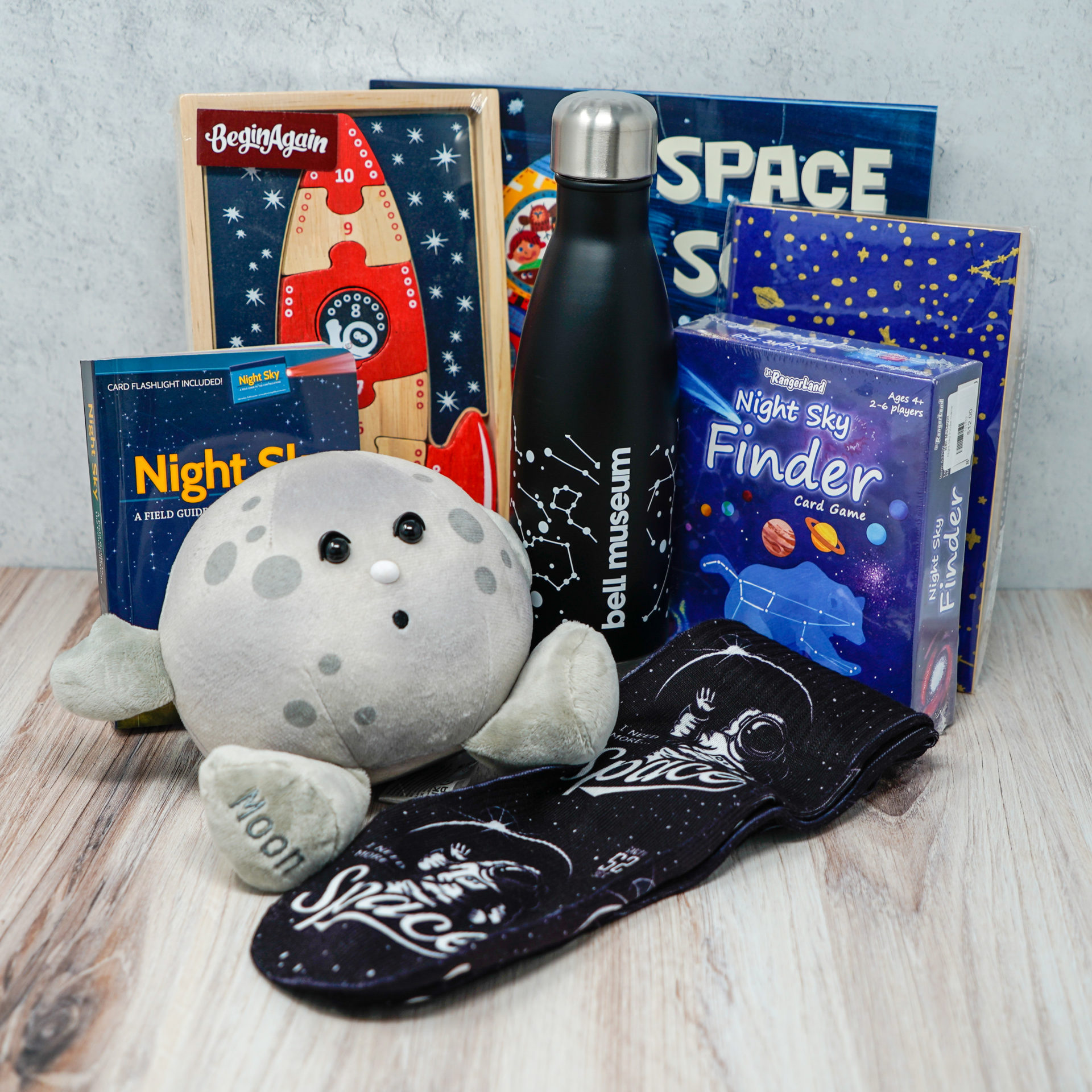 An assortment of space related gifts such as a plush moon and space socks