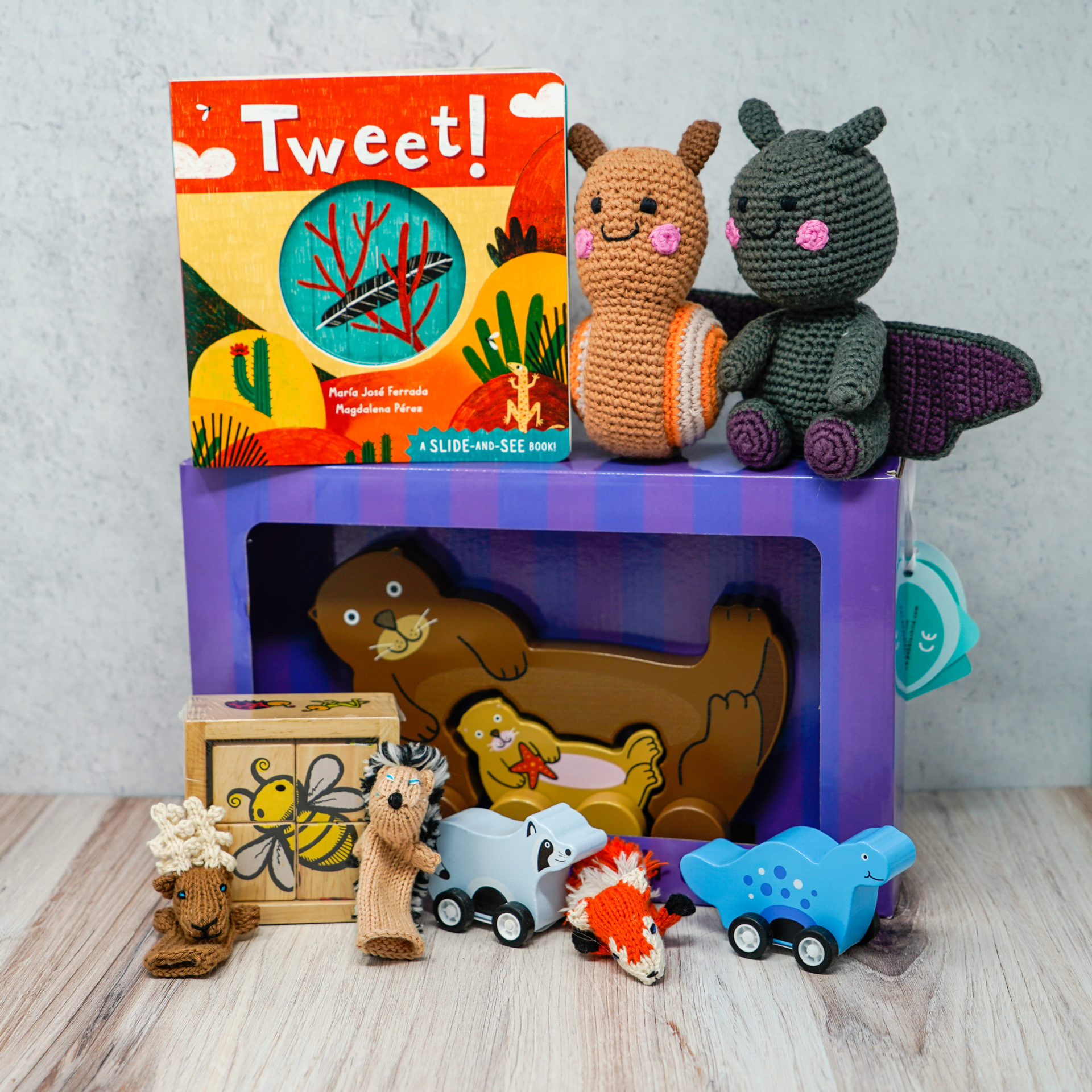 An assortment of gifts for toddlers including plush toys, finger puppets, and books