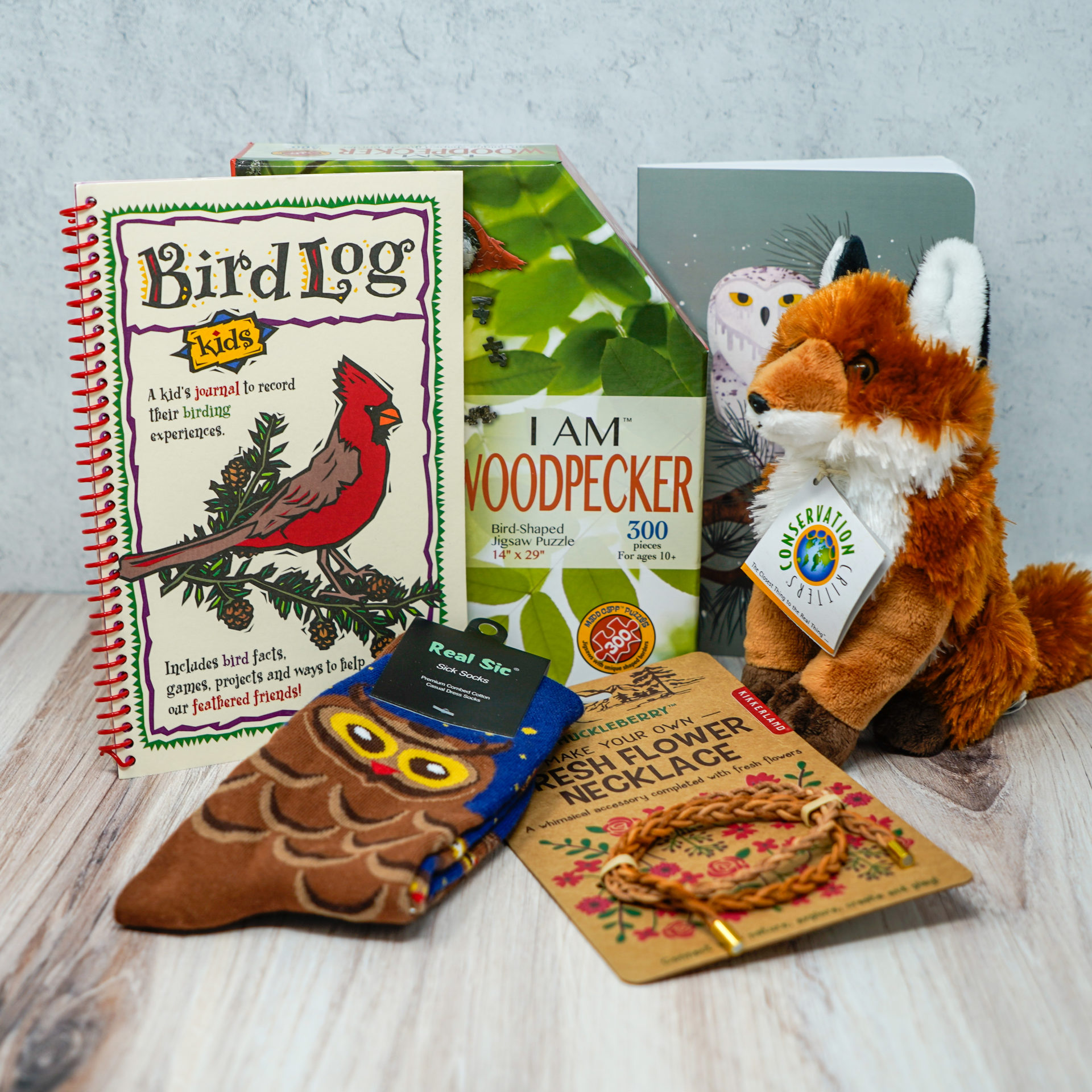 An assortment of gifts such as a plush fox, a bird log, and owl socks