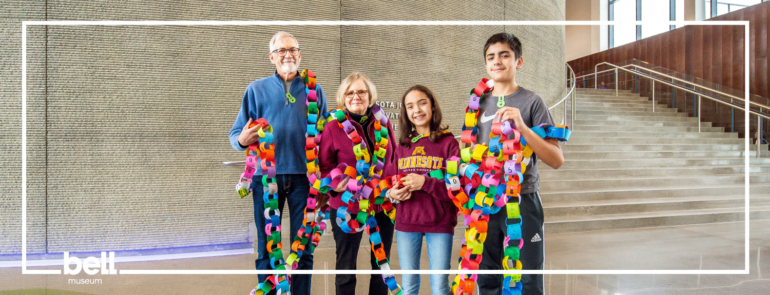 A group of 4 people holds a paper chain with the digits of pi with text: 150 years.
