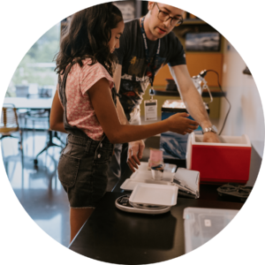 Adult showing child how to complete lab activity.