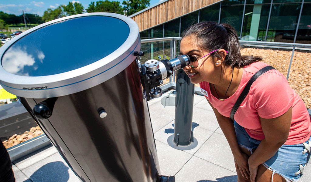 Adult looking through telescope
